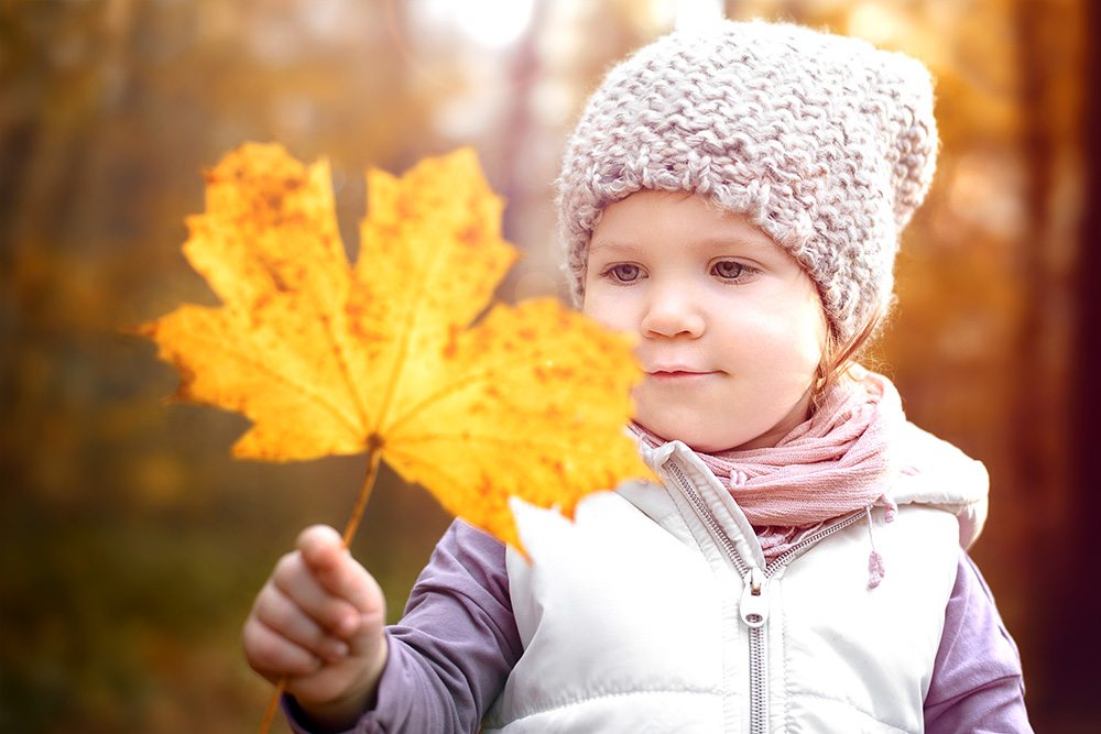 Kind mit Herbstlaub